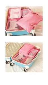 Six-piece pink travel organizer set neatly packed inside a blue suitcase detail view