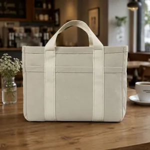 Vista frontal de un bolso tote de lona de varias capas sobre mesa de café
