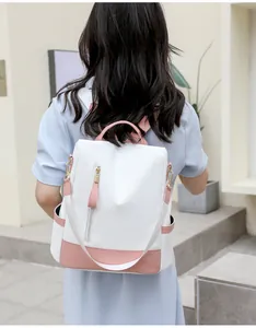 Vista posteriore di uno zaino antifurto bianco e rosa da donna indossato da una modella