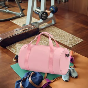 Detail view of a pink cylindrical waterproof sports bag in a fitness environment.