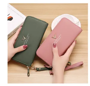 Detailed shot of green and pink women's long litchi grain zipper wallets with straps