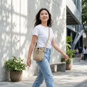 Lifestyle view of a lightweight beige nylon drawstring crossbody bag worn by a model
