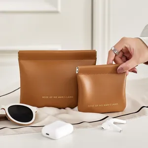 Detailed view of two brown leather pouches with automatic spring closure for cosmetics