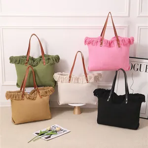 Detalle de varios bolsos de lona de gran capacidad con adornos de flecos en un estudio