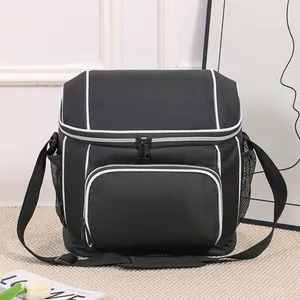 Black insulated picnic bag with white piping and shoulder strap for outdoor travel