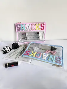 Detail of transparent PVC cosmetic bags with colorful embroidered SNACKS letters