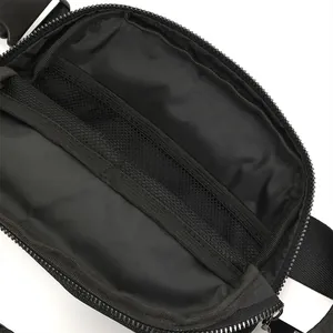Interior detail of black waist bag showing mesh zipper compartment for organization.
