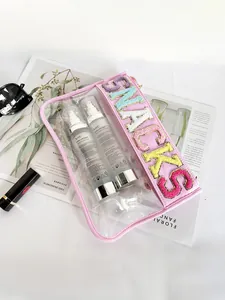 Close-up detail of a pink transparent PVC bag featuring colorful 3D SNACKS embroidery