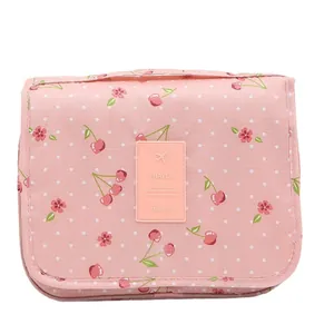 Pink travel toiletry bag with cherry and polka dot patterns and travel patch