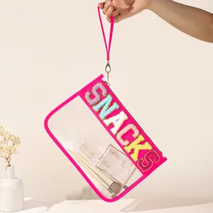 Close-up detail of hot pink transparent PVC pouch with colorful SNACKS letter embroidery