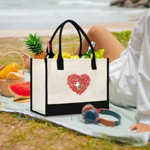 Large canvas tote bag with floral heart print at a beach picnic scene with fruit props