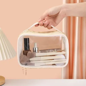 Close-up of a woven transparent makeup bag held by hand, showing brushes inside.