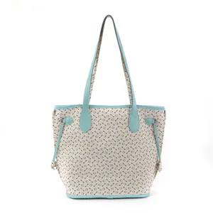 Detailed front view of a patterned tote bag with stylish turquoise trim and handles