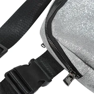 Macro detail of high-quality silver glitter fabric and black zipper on a crossbody chest bag