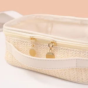 Close-up detail of the woven texture and golden zipper on this straw cosmetic bag