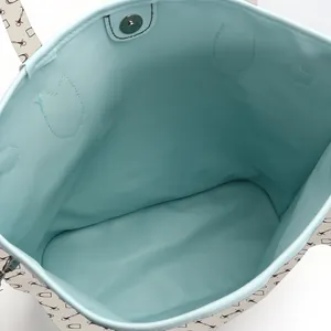 Interior detail showing the spacious mint green lining of a printed fashion tote bag