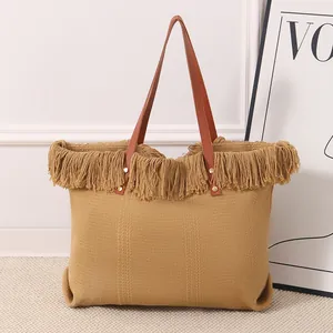 Detalle de primer plano del bolso de lona tejido amarillo mostaza con flecos densos