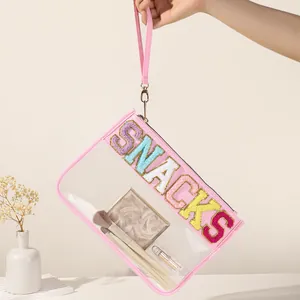 Close-up of pink transparent PVC storage bag with colorful embroidered SNACKS letters