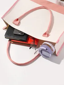 Detail view of the spacious pink and white canvas tote bag with daily essentials inside