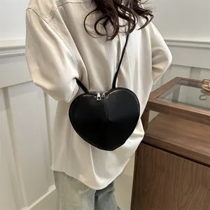 Stylish black heart-shaped leather crossbody bag for women, perfect for casual daily outings