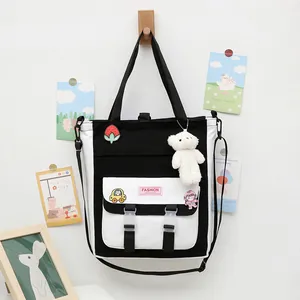 Bolso de lona blanco y negro para estudiantes con parches y un oso de peluche