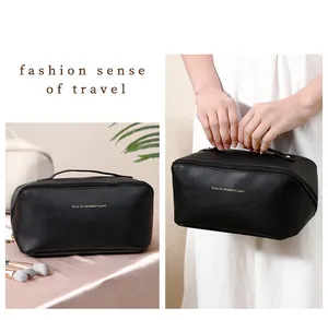 Large black makeup bag with gold lettering shown in travel and lifestyle settings
