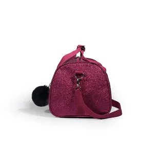 Side view of magenta glitter dance bag with shoulder strap and black pom-pom charm
