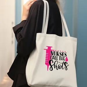 Bolsa de lona blanca con estampado de jeringuilla rosa y eslogan Nurses Call The Shots