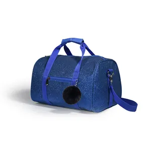 Close-up of blue glitter sports bag featuring a plush black pom-pom and adjustable strap