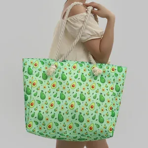Vista dettagliata di una grande borsa da spiaggia con stampa avocado e manici in corda per l'estate.