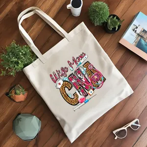 Vista detallada de bolsa de lona crema con diseño impreso de Wife Mom CNA médico