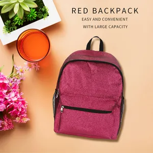 Pinkfarbener Glitzerrucksack in einem Flatlay mit dekorativen Blumen und Pflanzen