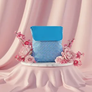 Detail view of a blue checkered drawstring cotton backpack on a floral marble base