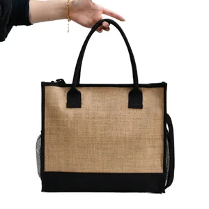 Dettaglio della borsa tote in juta minimalista con manici e texture in vista.