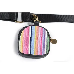 Detailed macro view of a small square woven coin pouch featuring vibrant colorful stripes
