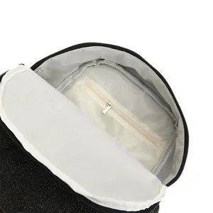 Detailansicht des Innenfutters und der Reißverschlusstasche eines schwarzen Glitzerrucksacks.