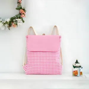 Detail of a pink and white checkered cotton drawstring backpack with a soft pink flap