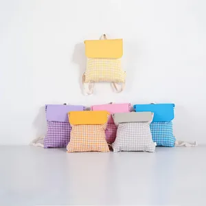 Detailed view of six colorful gingham drawstring cotton backpacks for students.
