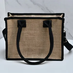 Vista dettagliata della borsa tote in iuta con bordi neri e tracolla staccabile.
