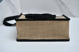 Vista dettagliata del fondo di una borsa tote in iuta con bordo nero e trama del tessuto