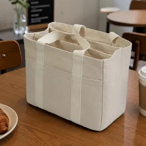Bolso tote de lona beige con múltiples compartimentos mostrando la estructura.