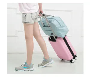 Large capacity foldable travel storage bag shown on a pink suitcase trolley handle