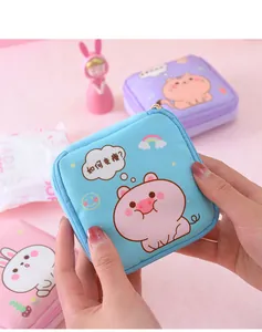 Detailed view of a cute blue cartoon pig sanitary pad storage pouch held in hands