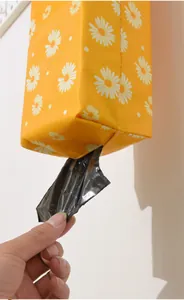 Detail einer gelben Aufbewahrungstasche mit Gänseblümchen für Müllbeutel