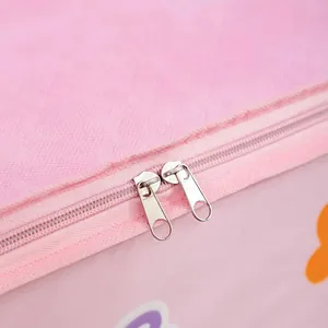 Macro close-up view of durable dual metal zippers on a pink non-woven fabric storage bag