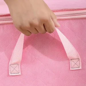 Close-up of durable reinforced handle on pink non-woven fabric storage bag.