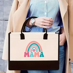 Close-up view of the stylish MAMA rainbow printed canvas tote bag held by a fashion model