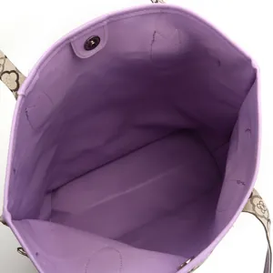 Interior view of large purple tote bag with magnetic closure and patterned straps.