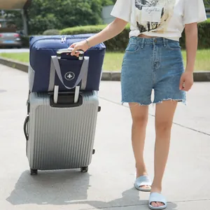 Navy blue foldable travel bag on a silver trolley suitcase for travel storage