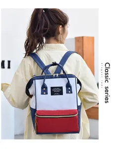 Back view of a stylish tricolor waterproof Oxford cloth mommy backpack on a model